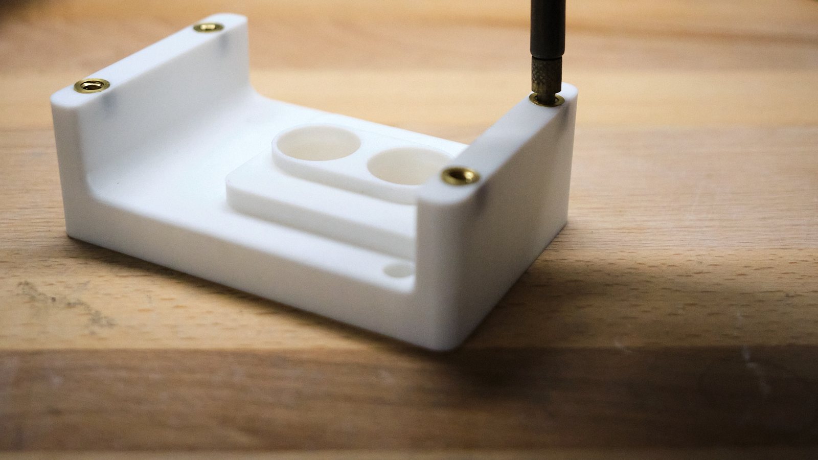 A brass heat-set insert going into a 3D-printed bracket